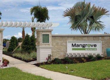 Mangrove Manor entrance sign with palm trees